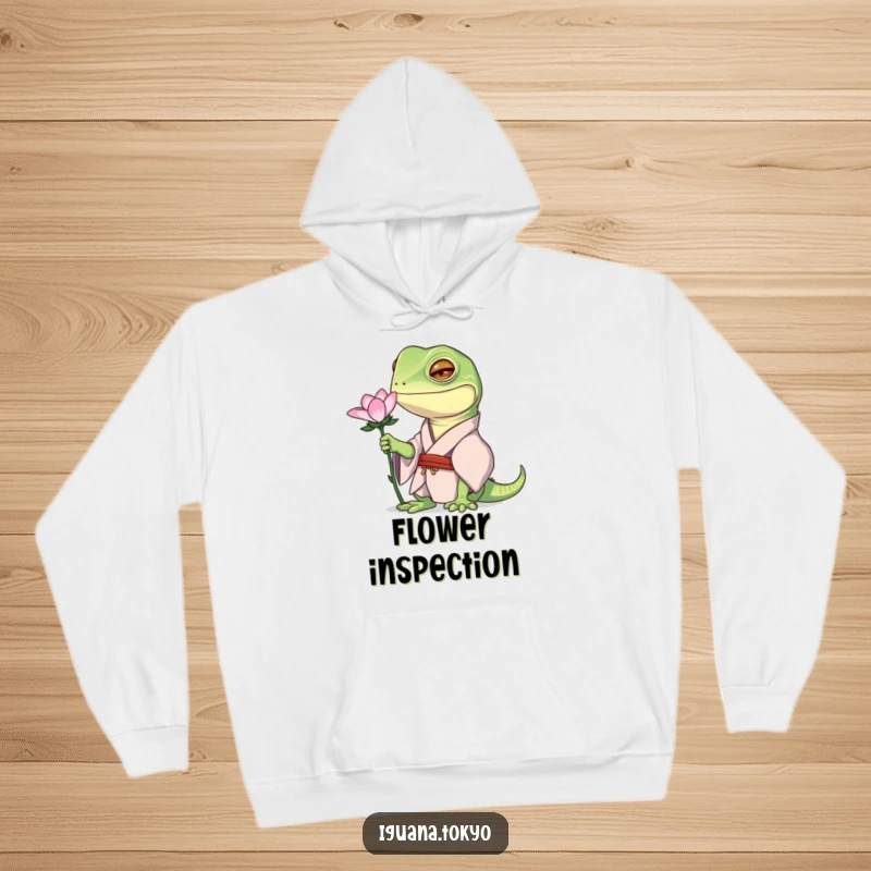 Funny hoodie depicting an iguana character in a kimono, curiously observing a flower, designed for cozy contemplation.